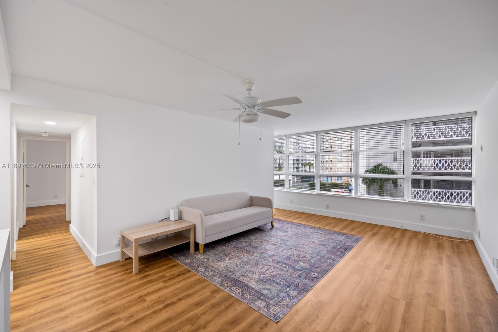 1440 Brickell Bay Drive, Unit 307 Miami, FL 33131 - Photo 6 of 28 a living room with furniture and a wooden floor