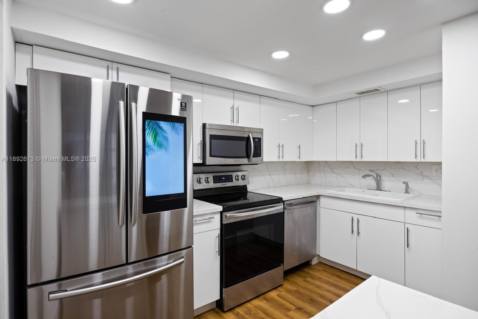 1440 Brickell Bay Drive, Unit 307 Miami, FL 33131 - Photo 8 of 28 a kitchen with a refrigerator sink and microwave