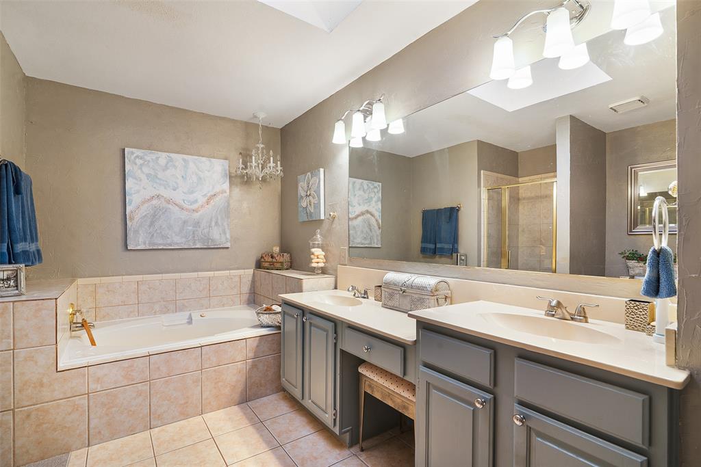 409 Red River Trail Irving, TX 75063 - Photo 17 of 31 a bathroom with a tub a sink double vanity and a mirror