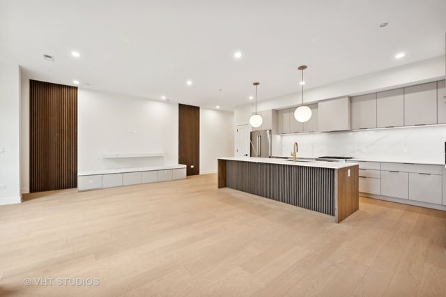 a large kitchen with stainless steel appliances granite countertop a large counter top and a stove top oven