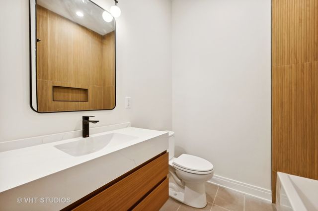 a bathroom with a toilet a sink and mirror