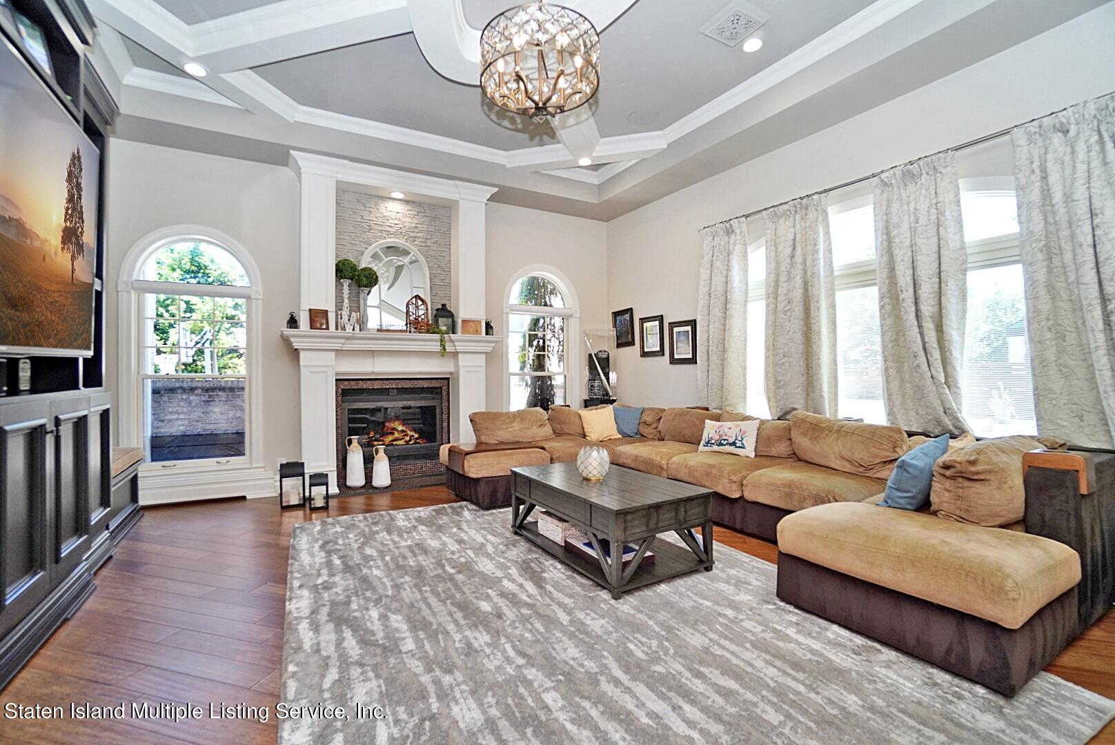 312 Shore Road Staten Island, NY 10307 - Photo 29 of 73 a living room with furniture a chandelier and a fireplace