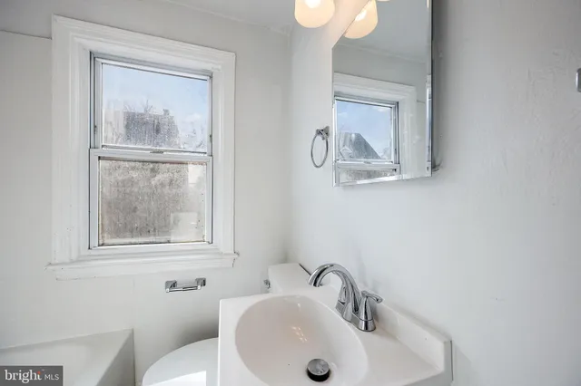 a bathroom with a toilet sink and mirror
