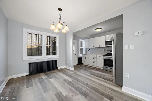 a view of a kitchen with wooden floor and a window