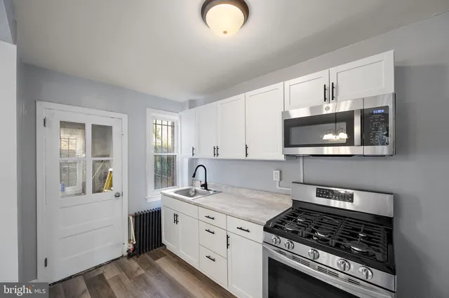a kitchen with stainless steel appliances granite countertop a stove a sink and a microwave
