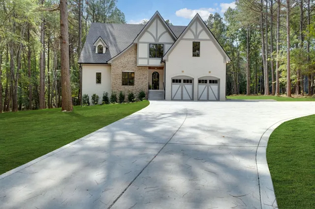 a view of a white house with a big yard and large trees