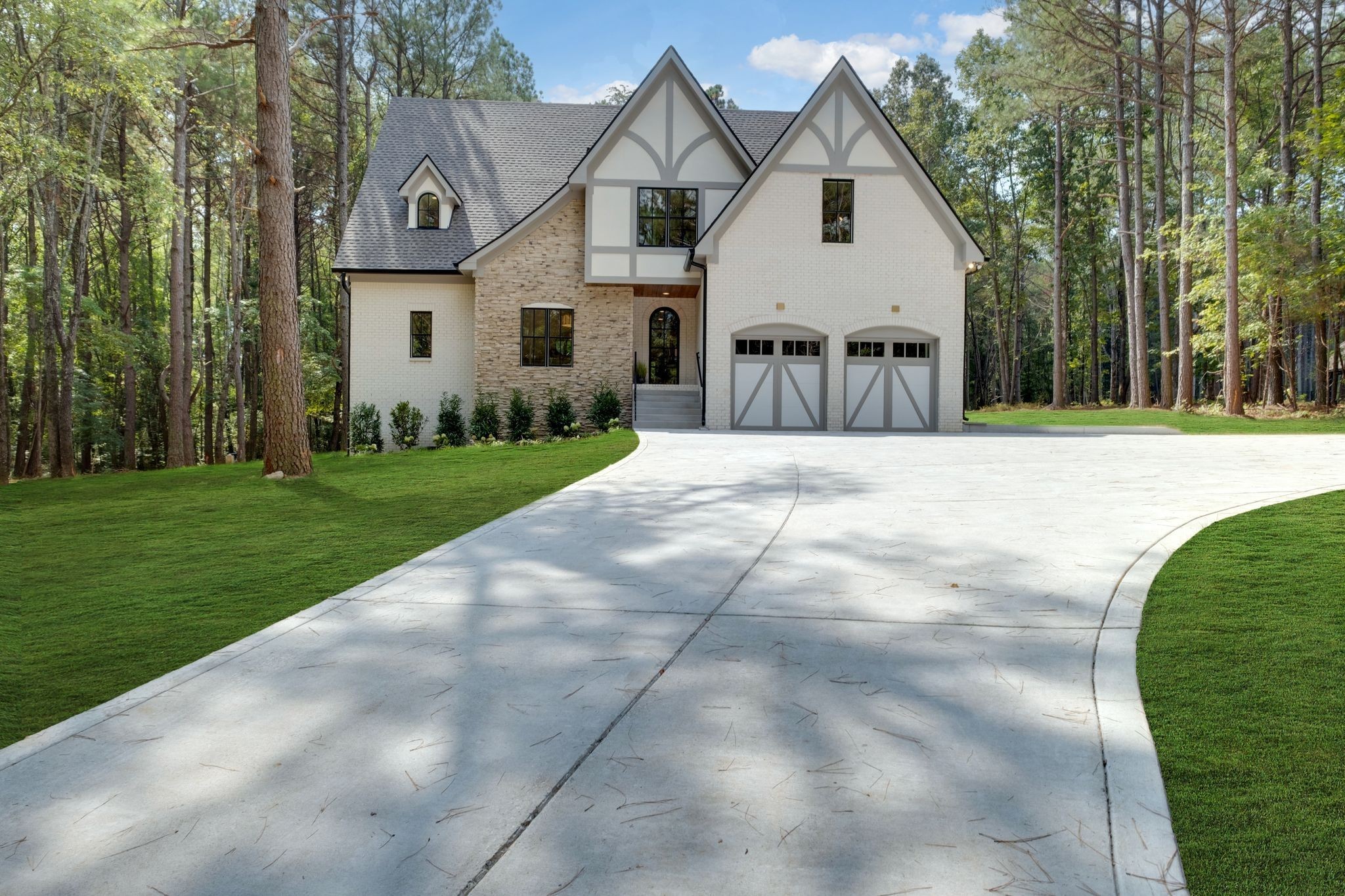 a view of a white house with a big yard and large trees