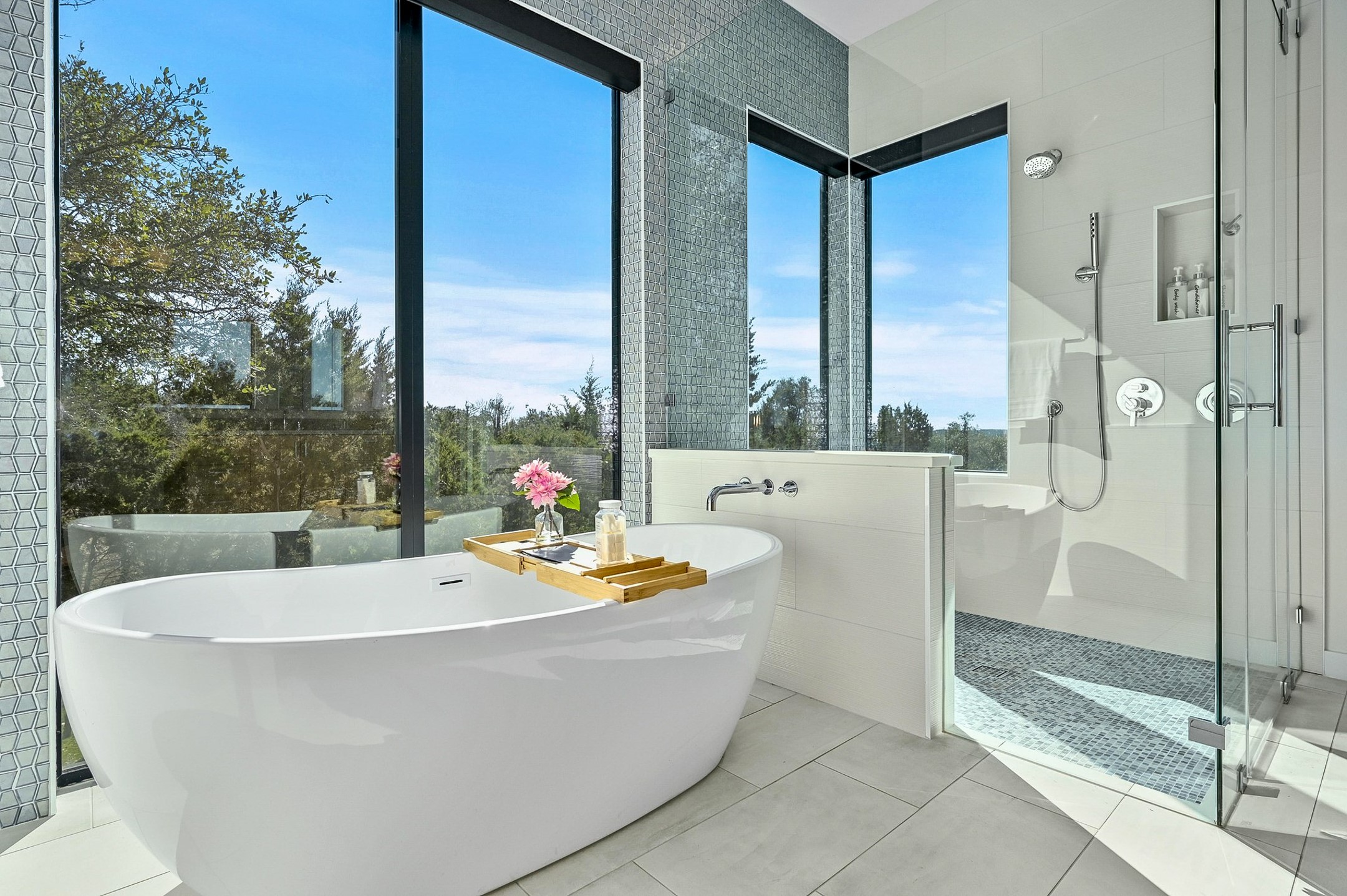 475 Happy Trail Dripping Springs, TX 78620 - Photo 15 of 40 This bathroom features a freestanding soaking tub positioned by large windows, offering expansive views. Automatic shades throughout the property for easy privacy when desired.