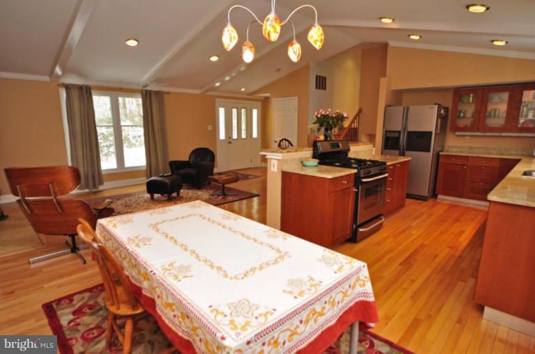 2509 Foxcroft Way Reston, VA 20191 - Photo 15 of 22 a kitchen with stainless steel appliances kitchen island granite countertop a stove a sink dishwasher and a dining table with wooden floor