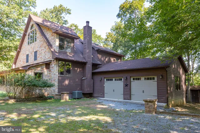 a backyard of a house with table and chairs large with wooden fence and plants