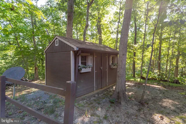 a kitchen with stainless steel appliances kitchen island granite countertop wooden floors and a view of living room