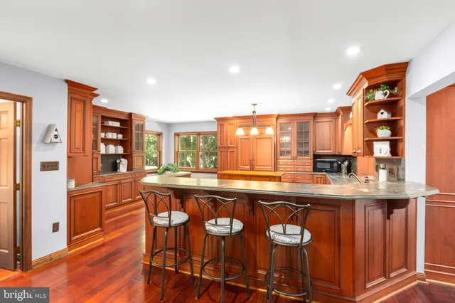 a living room with furniture a wooden floor and a large window