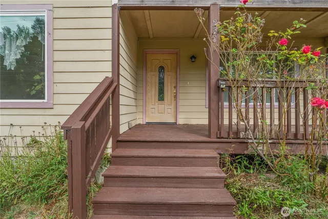 a view of a house with wooden fence and flowers