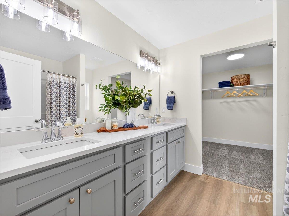 1611 Regency Way Emmett, ID 83617 - Photo 25 of 47 Full bath with double vanity, a shower with shower curtain, light wood-style floors, and a walk in closet