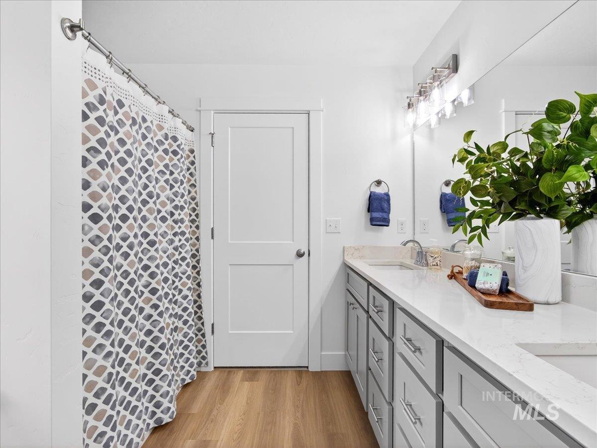 1611 Regency Way Emmett, ID 83617 - Photo 27 of 47 Full bathroom featuring double vanity, light wood-style flooring, and a shower with shower curtain