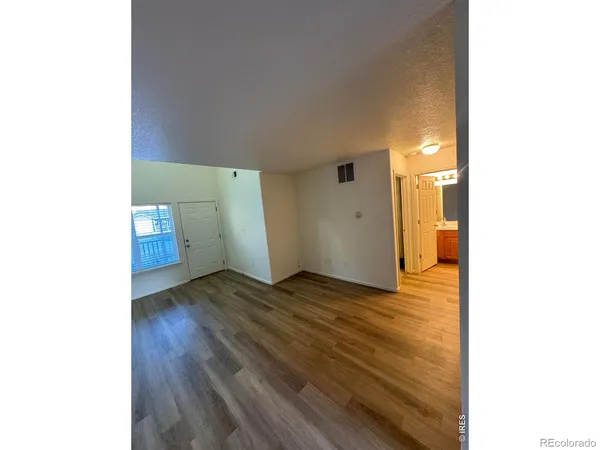 a view of empty room with wooden floor