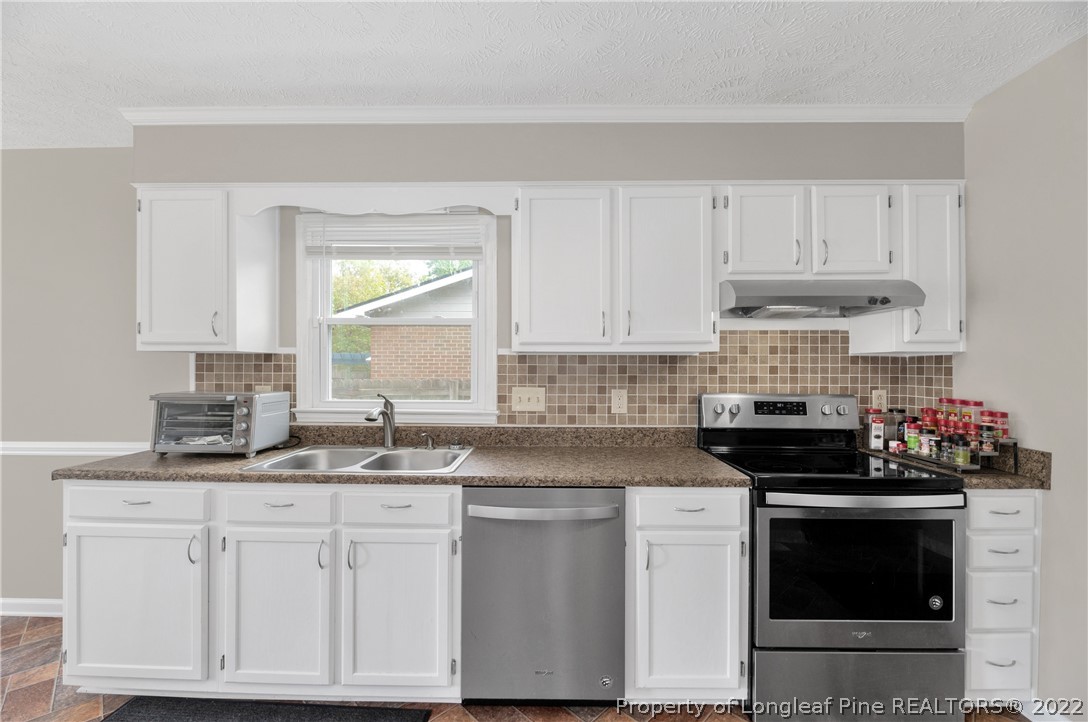 709 Riyhad Road Fayetteville, NC 28314 - Photo 7 of 29 a kitchen with white cabinets and black appliances