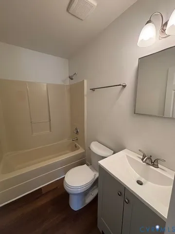 a bathroom with a toilet sink vanity tub and shower