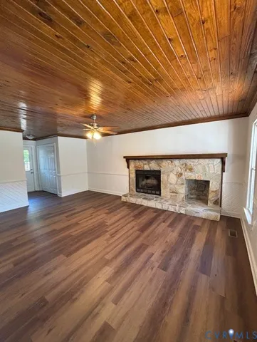 an empty room with wooden floor and fireplace
