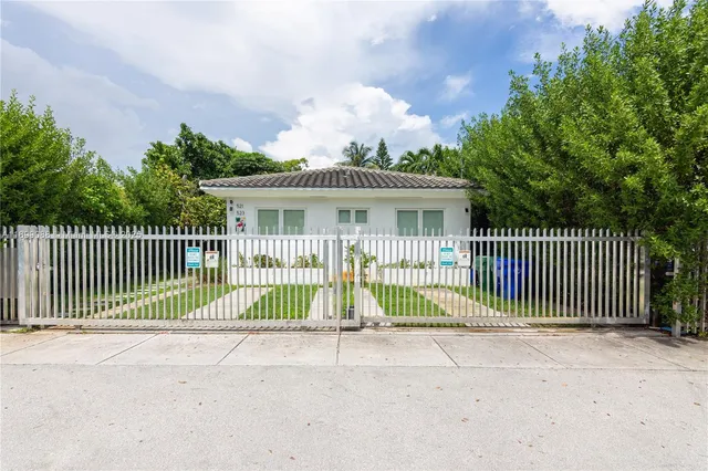 a view of a house with a fence and a trees