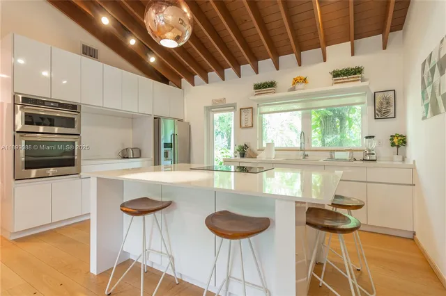 a kitchen with a sink a counter top space stainless steel appliances and a window