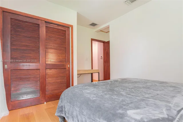 a white bed sitting in a bedroom next to a window