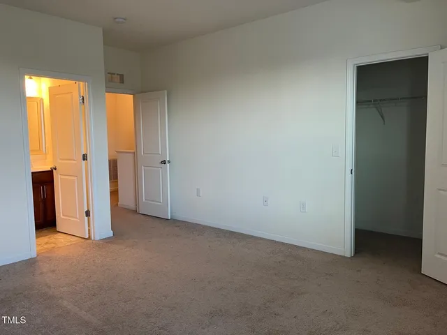 an empty room with a window and a kitchen