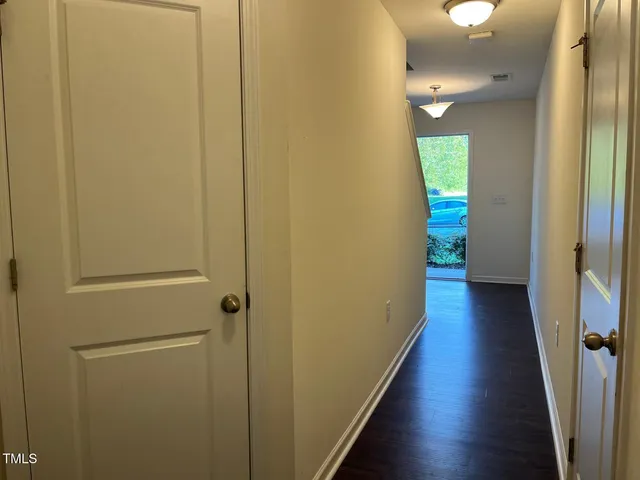 a view of a hallway with wooden floor