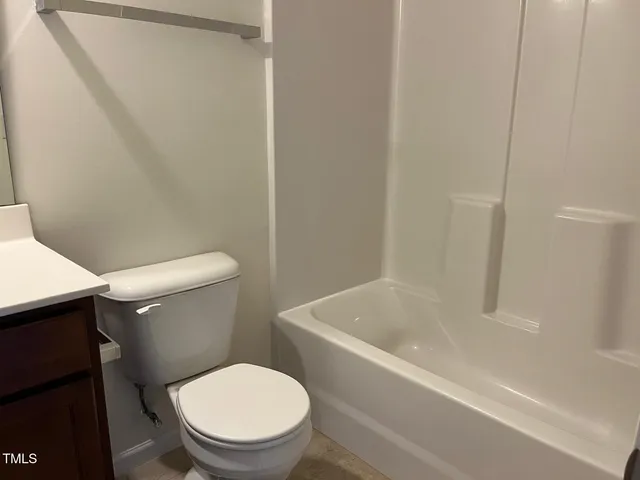 a white toilet sitting next to a bath tub