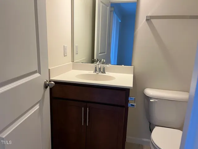a bathroom with a sink a toilet a mirror and shower curtain