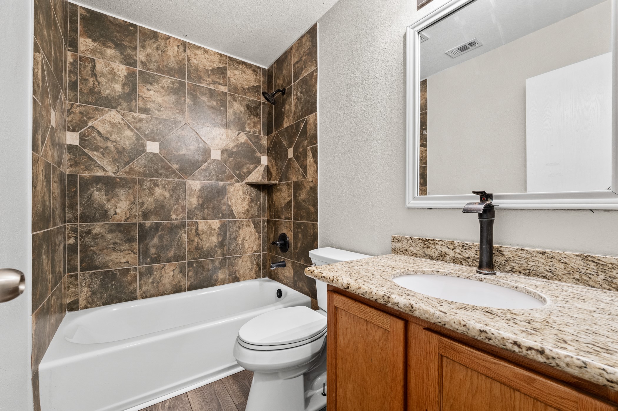 7731 Saddle Run Selma, TX 78154 - Photo 22 of 24 a bathroom with a granite countertop sink toilet and bathtub