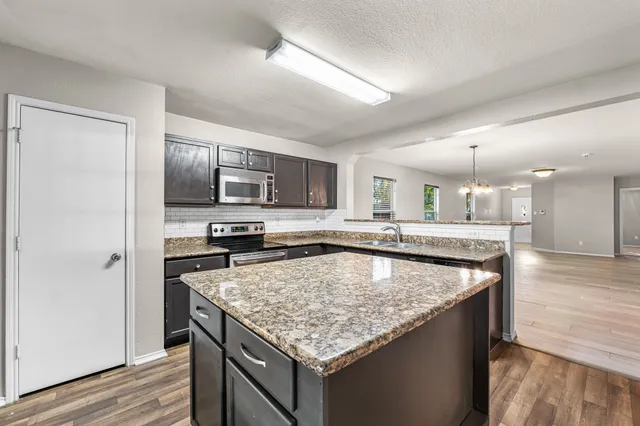 a kitchen with a stove sink and microwave