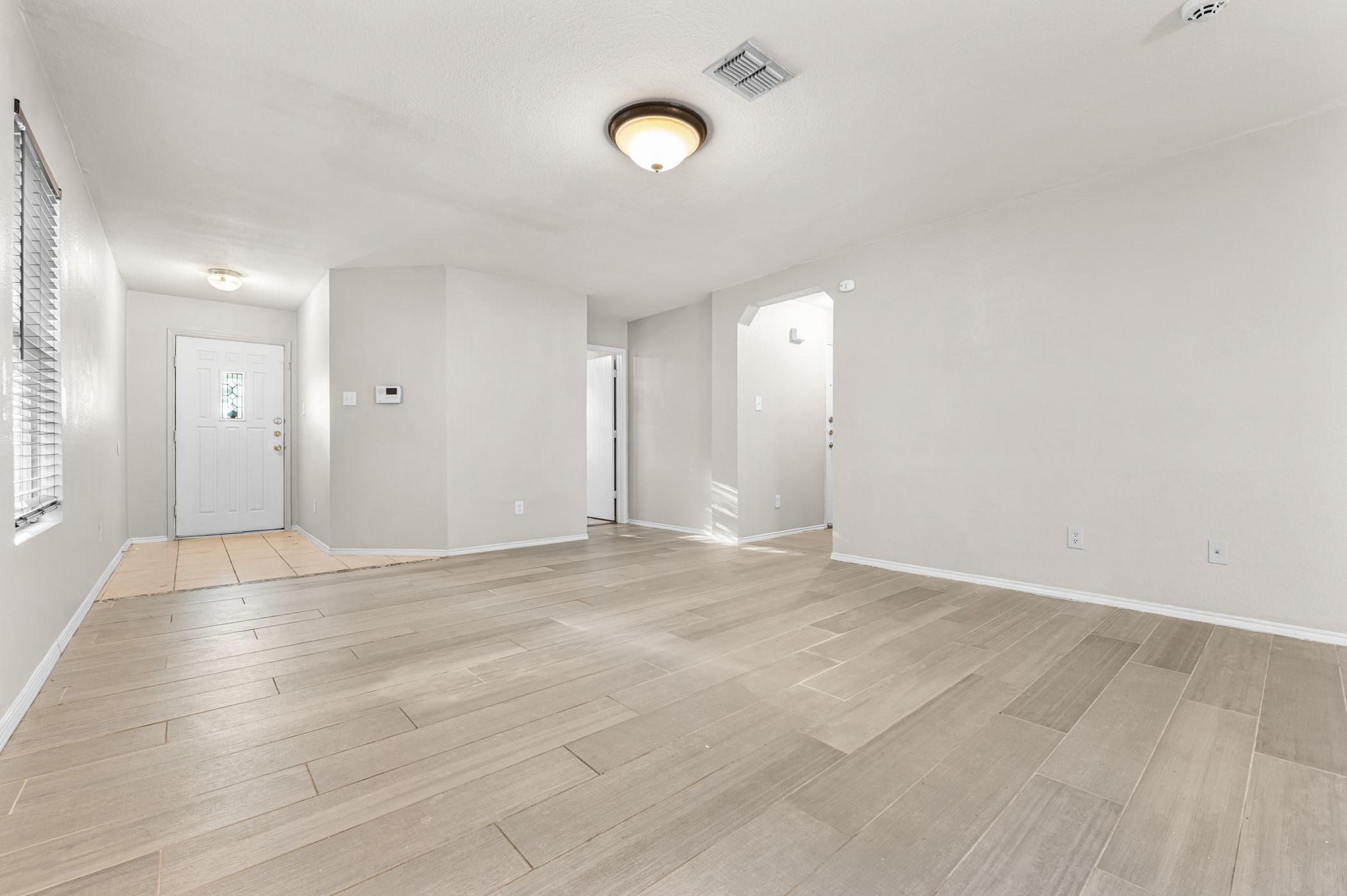 7731 Saddle Run Selma, TX 78154 - Photo 9 of 24 a view of an empty room with wooden floor and a window