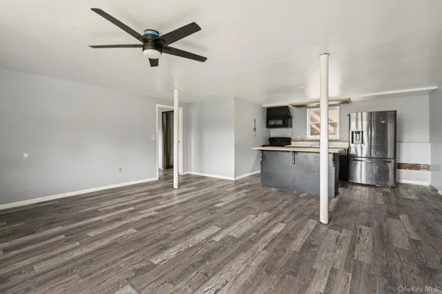 a view of a kitchen with a stove wooden cabinet wooden floor a kitchen view and wooden floor