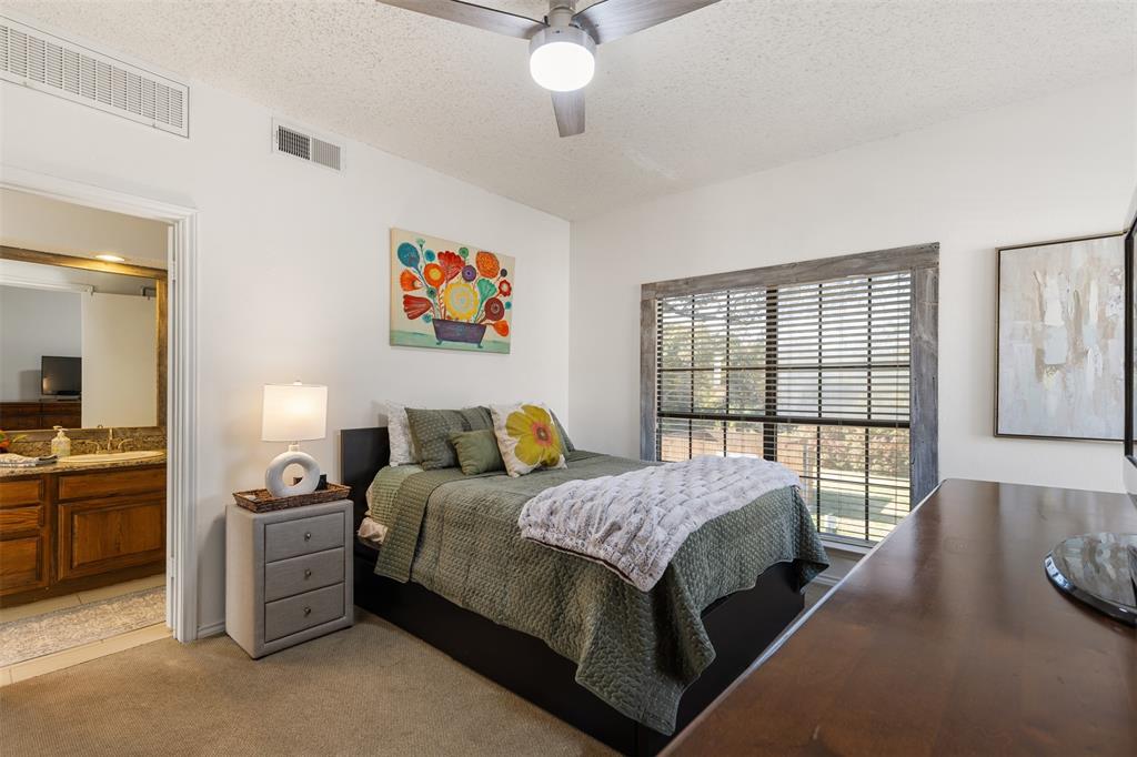 5619 Preston Oaks Road, Unit 502 Dallas, TX 75254 - Photo 20 of 33 a spacious bedroom with a bed a couch and a large window