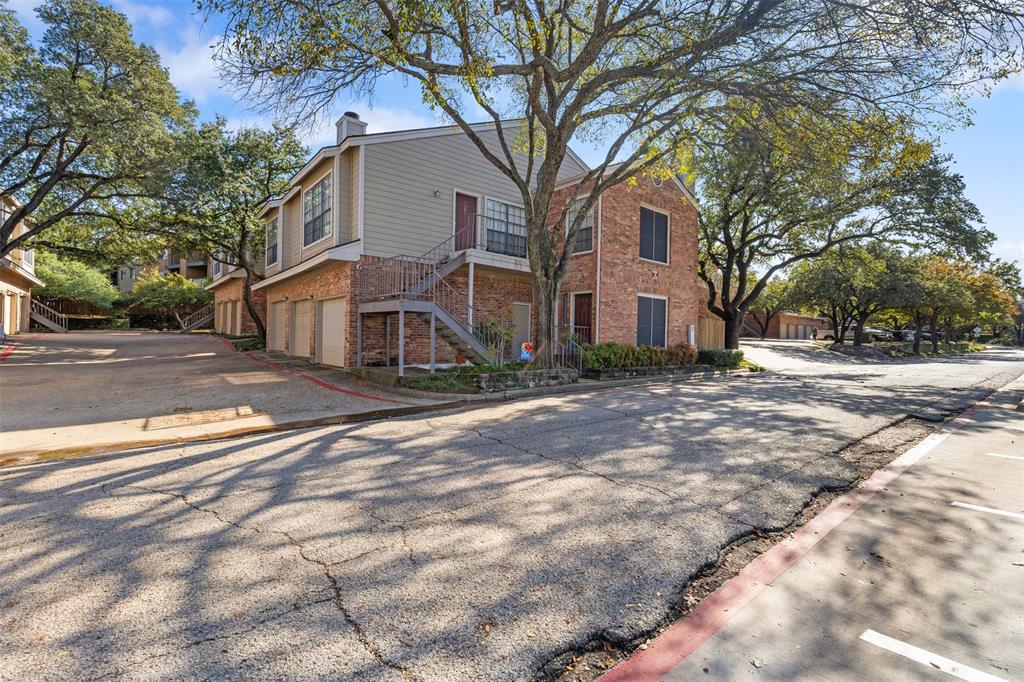 5619 Preston Oaks Road, Unit 502 Dallas, TX 75254 - Photo 30 of 33 a front view of a house with a yard and large trees