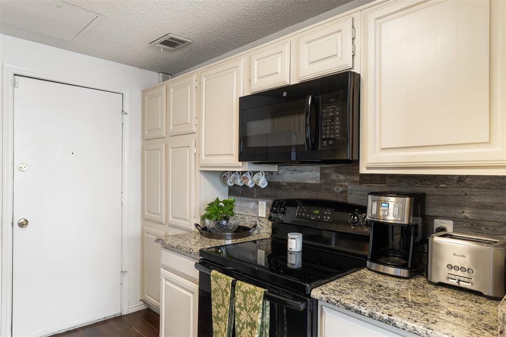 5619 Preston Oaks Road, Unit 502 Dallas, TX 75254 - Photo 7 of 33 a kitchen with stainless steel appliances granite countertop a stove a microwave and refrigerator