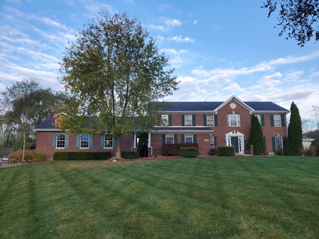 front view of a brick house with a yard