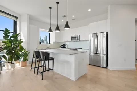 a kitchen with granite countertop a sink stainless steel appliances and cabinets