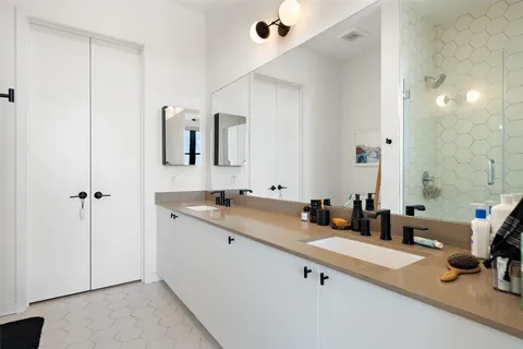 a en suite bathroom with a double vanity sink and a mirror