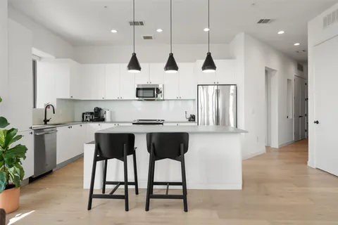 a kitchen with white cabinets and stainless steel appliances