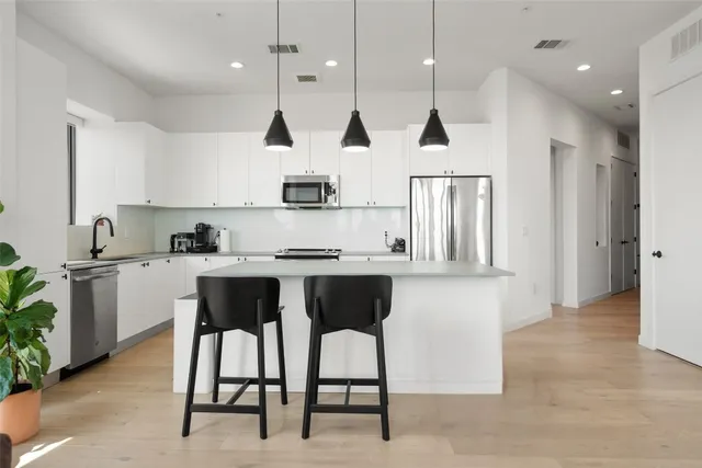 a kitchen with white cabinets and stainless steel appliances