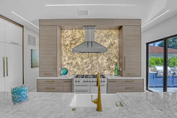 a large white kitchen with a large window and sink