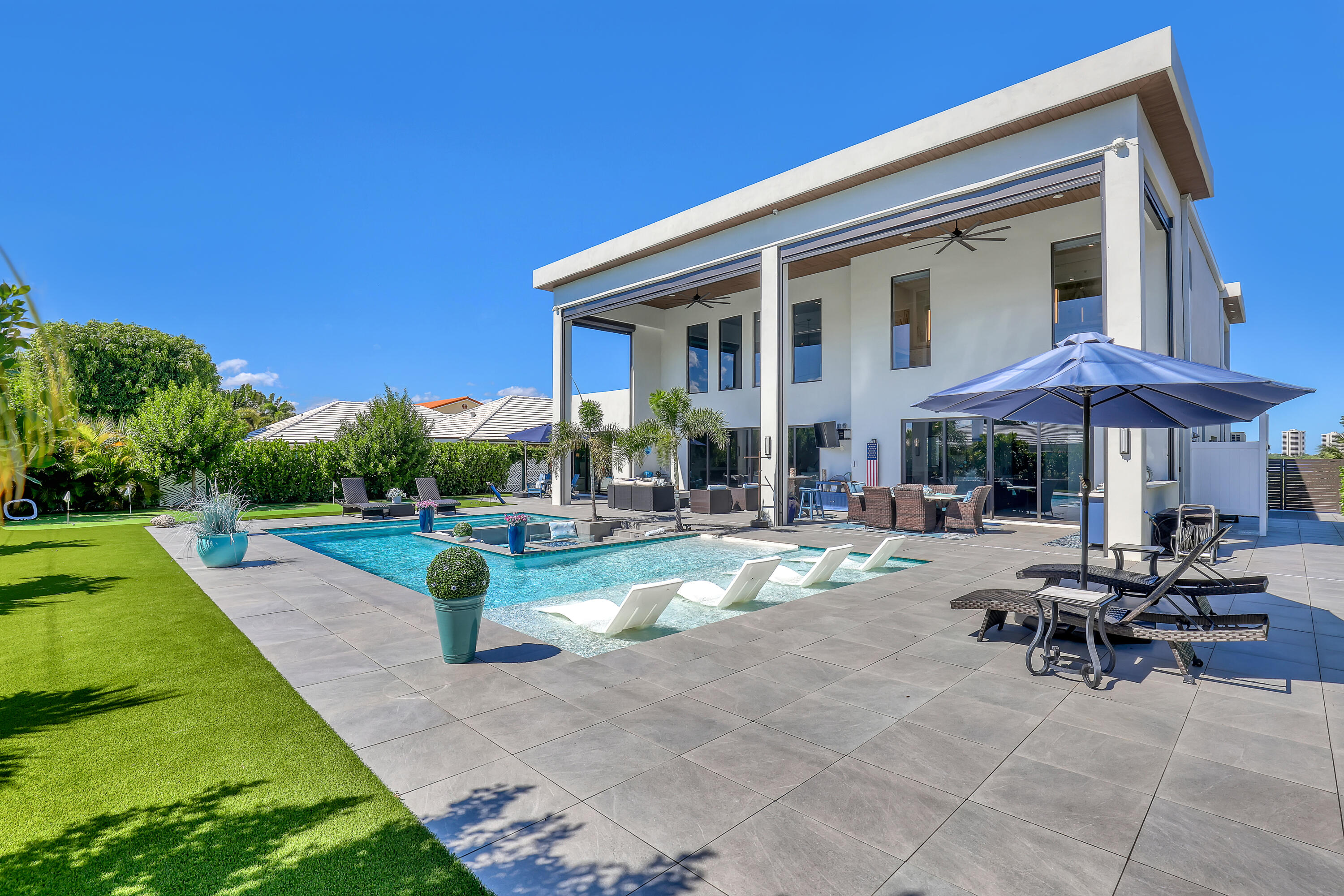 1161 Pine Point Road Riviera Beach, FL 33404 - Photo 53 of 58 a view of a patio with chairs and a table under an umbrella