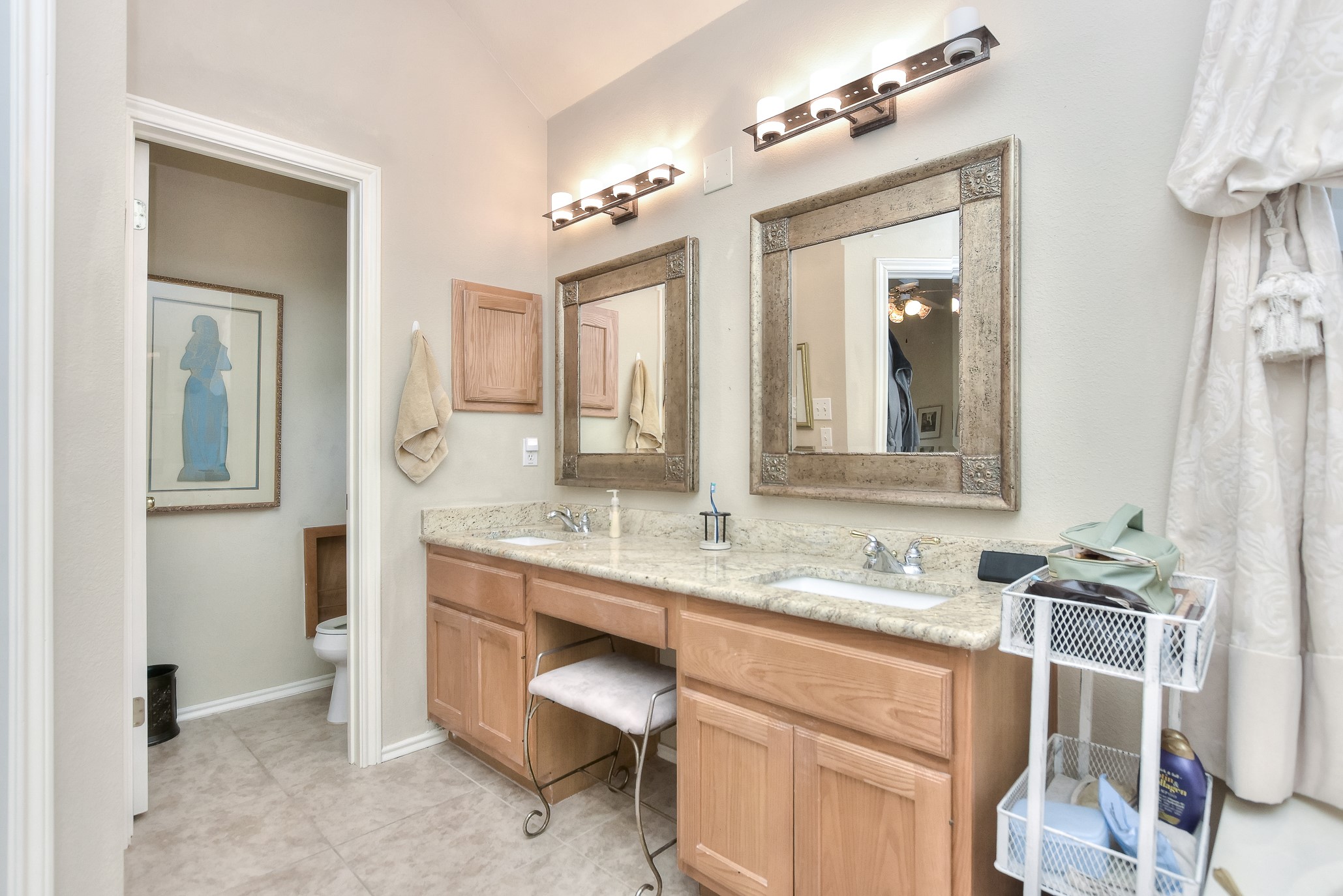 1609 Colton Way Cedar Park, TX 78613 - Photo 13 of 24 Dual vanity with elegant granite counters and warm wood cabinetry, enhancing a functional bathroom space.