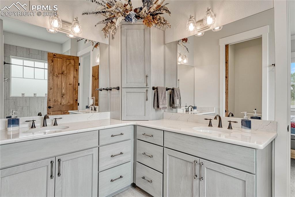1183 2nd Street Penrose, CO 81240 - Photo 23 of 50 a bathroom with double vanity sinks a vanity a lamp and a mirror
