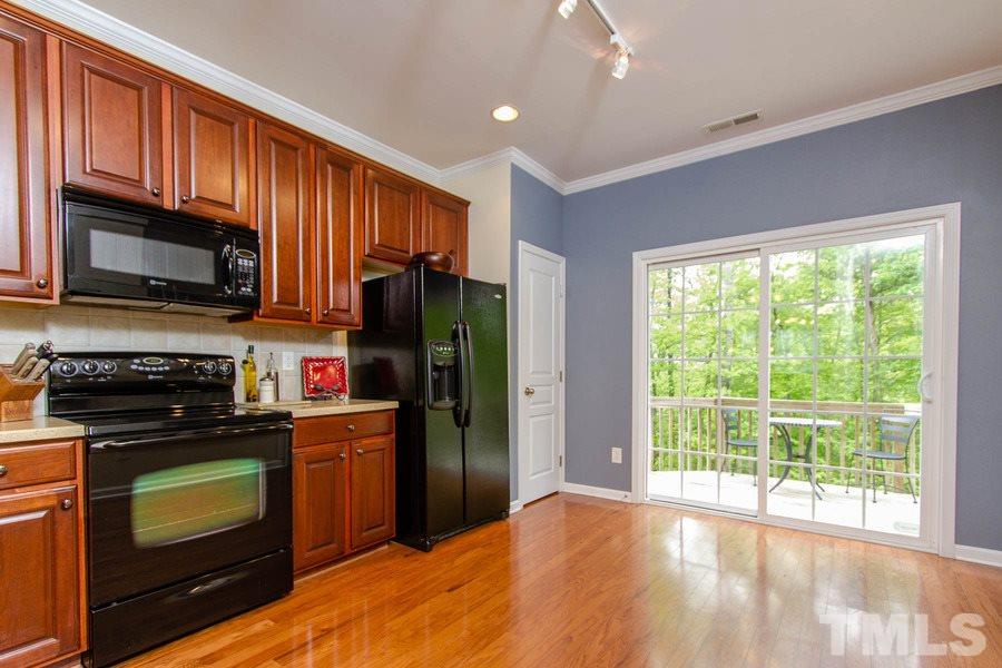 Kitchen has AMPLE counter space and overlooks peaceful GREEN SPACE.
