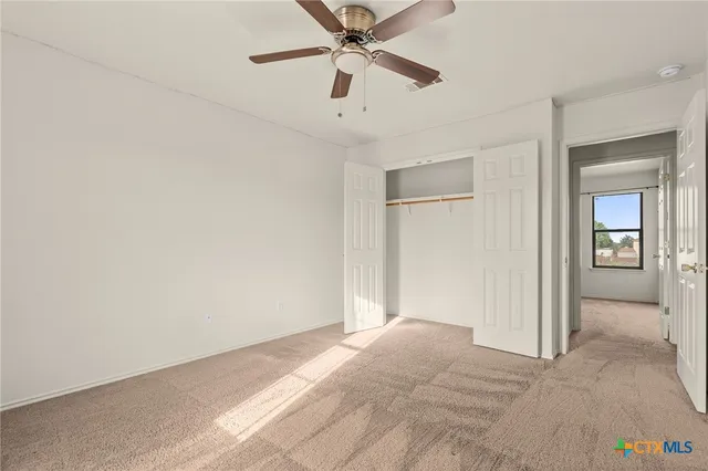 a view of a livingroom with a ceiling fan and window