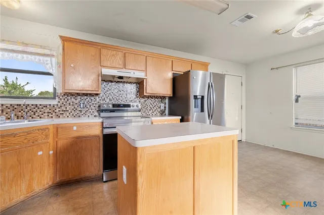 a kitchen with stainless steel appliances granite countertop a sink and cabinets