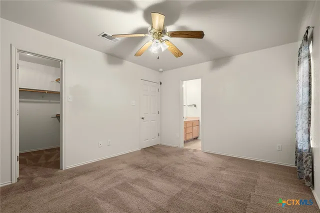 a view of an empty room with a ceiling fan